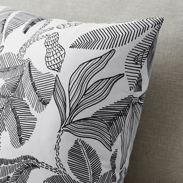 Coussin à motifs de feuilles noires et blanches, toucher coton croustillant, matériau recyclé, design moderne et élégant.
