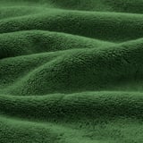 Des serviettes biologiques vertes douces et moelleuses soigneusement pliées, mettant en valeur leur texture épaisse et absorbante et leur élégante bordure tissée.