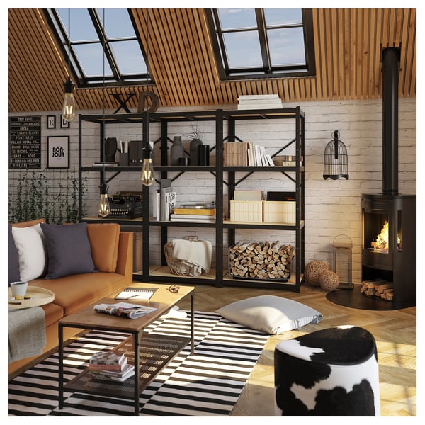 Salon moderne avec des étagères en métal noir BROR, des étagères en bois de pin et un canapé orange, éclairé par des lampes suspendues.