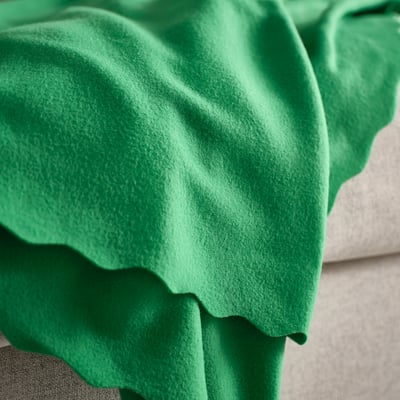 Couverture polaire verte, douce et douillette, soigneusement pliée. Fabriqué à partir de 90 % de polyester recyclé.