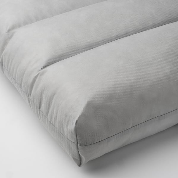Coussin moelleux gris clair, soigneusement cousu, montrant une texture douce et de soutien.