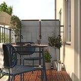 Balcon avec table et chaises bleues DUVSKÄR, plantes, mur blanc.