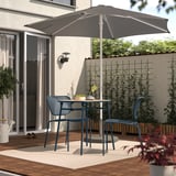 Configuration de patio confortable avec parasol gris, chaises bleues, table en bois et plantes.