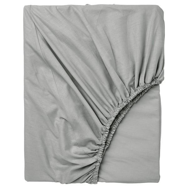 Un drap-housse DVALA gris clair, en coton doux, conçu pour s’adapter aux matelas jusqu’à 26 cm d’épaisseur avec des bords élastiques.