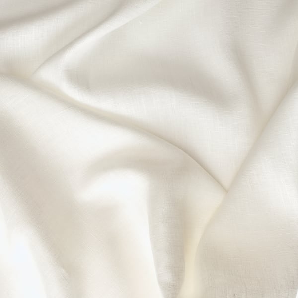 Tissu en lin blanc doux plissé en plis doux, mettant en valeur la texture naturelle et la qualité du matériau.