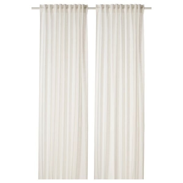 Les rideaux en lin blanc pendent droits, offrant de l’intimité avec un tissu transparent.