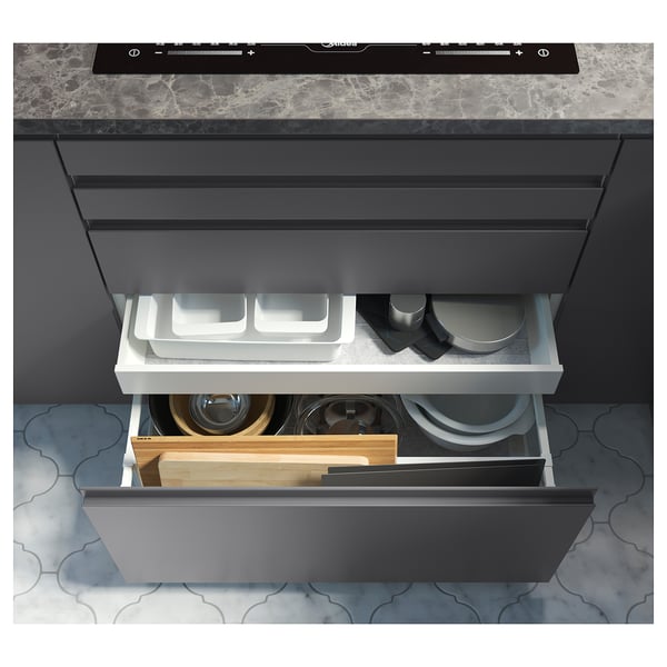 Est d’un tiroir de cuisine ikea EKBACKEN gris avec divers ustensiles, y compris des planches à découper et des bols.