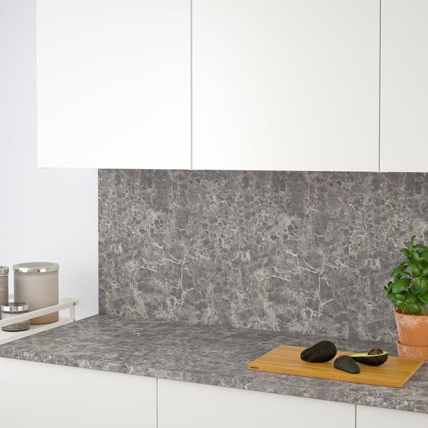 Comptoir de cuisine avec avocats, plante en pot et bougie. Plan de travail moderne en stratifié aspect marbre gris d’ikea, facile à nettoyer.