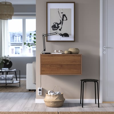 Armoire en bois EKET avec 2 tiroirs, peinture abstraite, panier, tabouret noir.