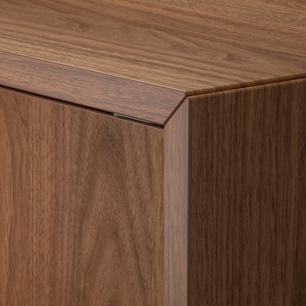 Gros plan d’un motif de grain de bois de haute qualité sur une armoire brun foncé avec bord de porte affleurant.