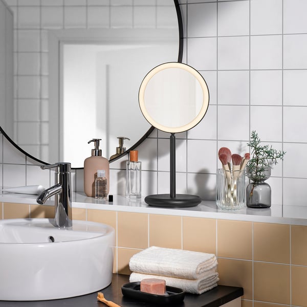 Miroir Ekfann sur le comptoir de la salle de bain. Noir, rond, grossissant et dimmable.