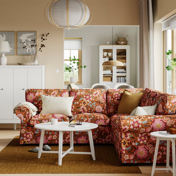 Canapé sectionnel EKTORP dans le salon avec imprimé floral et décoration blanche.