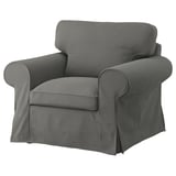 Un fauteuil EKTORP gris avec des coussins moelleux et des accoudoirs roulés, offrant un design confortable et intemporel.