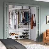 Armoire ELVARLI dans la chambre avec étagères, section suspendue et chaise orange.