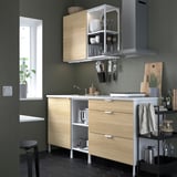 Cuisine moderne avec des armoires en bois clair, des appareils électroménagers en acier inoxydable et un comptoir noir.
