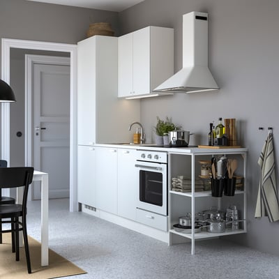 Cuisine blanche moderne avec des armoires blanches, des appareils électroménagers en acier inoxydable et des comptoirs organisés.