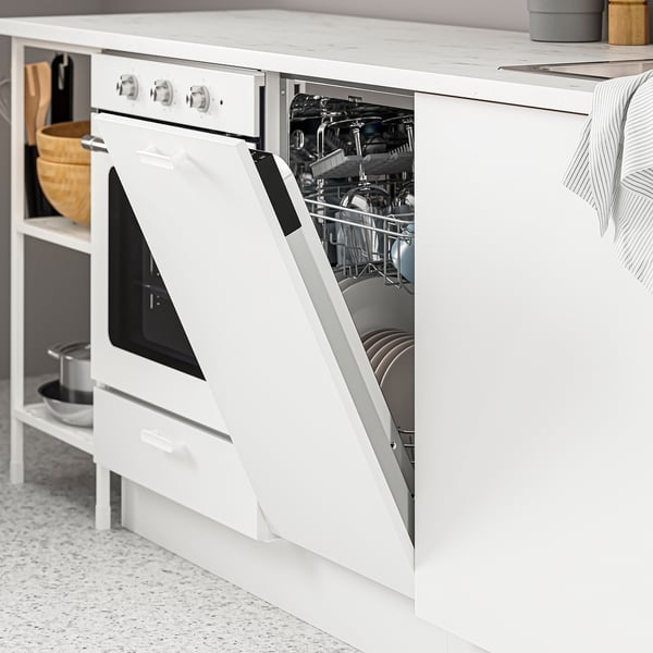 Lave-vaisselle blanc ouvert rempli de vaisselle propre dans la cuisine moderne, montrant son rangement fonctionnel.