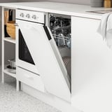 Lave-vaisselle blanc ouvert rempli de vaisselle propre dans la cuisine moderne, montrant son rangement fonctionnel.