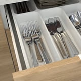 Tiroir de cuisine organisé avec plusieurs compartiments, rangeant parfaitement les fourchettes, les couteaux et les cuillères pour un accès facile.
