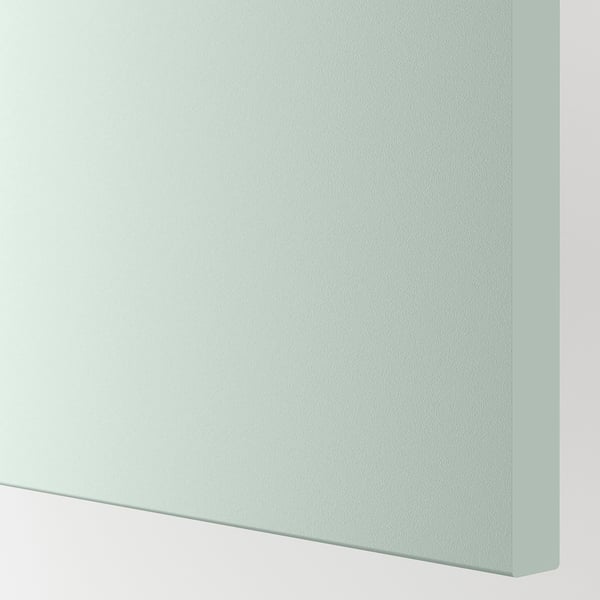 Gros plan de la surface lisse et pâle de l’armoire gris-vert, mettant en valeur une finition et une texture de haute qualité.