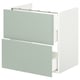 Une armoire de salle de bain à deux tiroirs vert clair au design élégant.