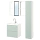 Configuration moderne de la salle de bains : meuble lavabo mural vert pâle avec deux tiroirs, robinet chromé, armoire haute, étagères ouvertes et miroir encadré.