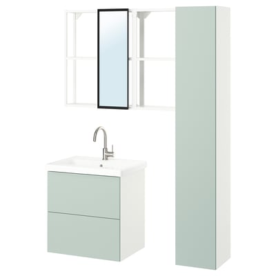 Configuration moderne de la salle de bains : meuble lavabo mural vert pâle avec deux tiroirs, robinet chromé, armoire haute, étagères ouvertes et miroir encadré.