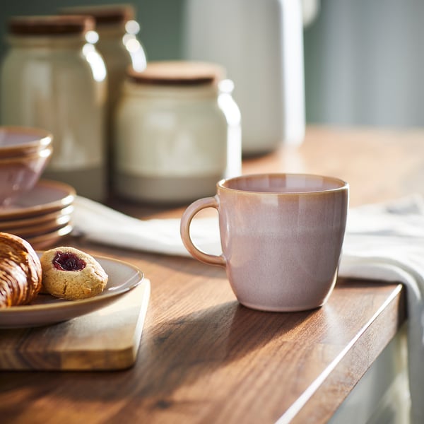 Tasse FÄRGKLAR sur une table en bois, à côté de pâtisseries, de bocaux et de plats. Couleur rustique, design simple, matériau en grès, taille moyenne.