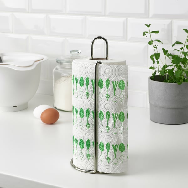Support en métal avec torchons de cuisine à deux épaisseurs, affichant un motif végétal vert, reposant sur un comptoir blanc.