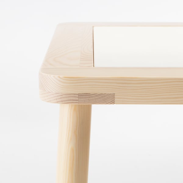 Un bureau en bois clair robuste avec des joints soignés, montrant un savoir-faire de haute qualité.