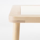 Un bureau en bois clair robuste avec des joints soignés, montrant un savoir-faire de haute qualité.