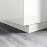 Imaginez un socle de cuisine blanc brillant. Il couvre l’espace entre le sol et les armoires basses, offrant un aspect épuré et un nettoyage facile.