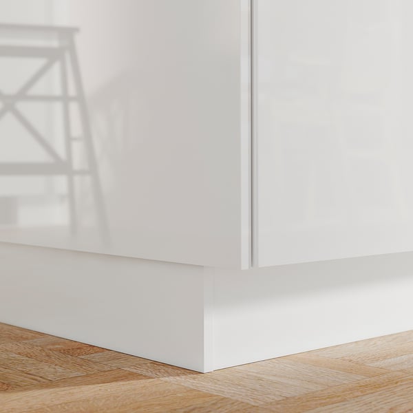 Un socle de cuisine FÖRBÄTTRA blanc. Il est élégant, brillant et repose au ras du plancher en bois.