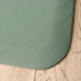 Tapis anti-fatigue rond vert sur plancher en bois, montrant une texture de qualité et une construction durable.
