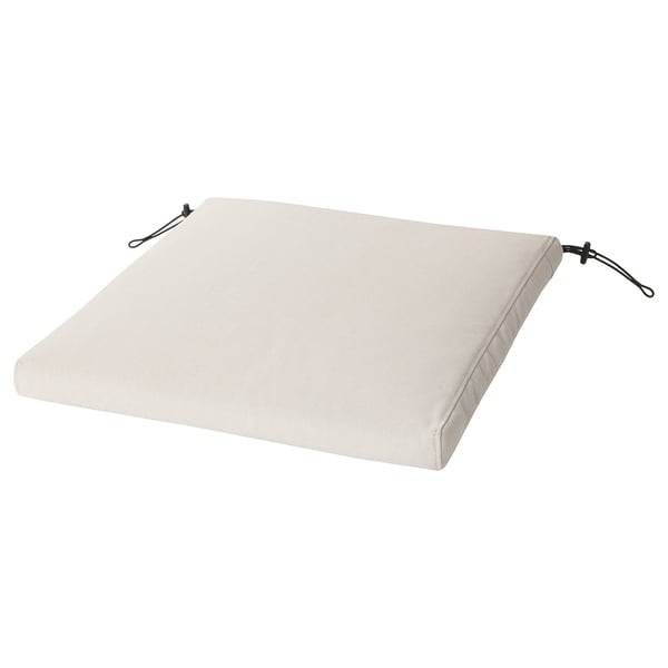 Coussin de chaise d’extérieur rectangulaire de couleur crème avec deux liens noirs. Confortable, résistant à l’eau, fabriqué à partir de matériaux recyclés.