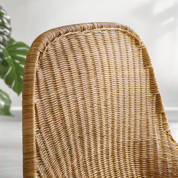 Gros plan d’un fauteuil en osier tressé, mettant en valeur un motif de rotin complexe et une texture naturelle.
