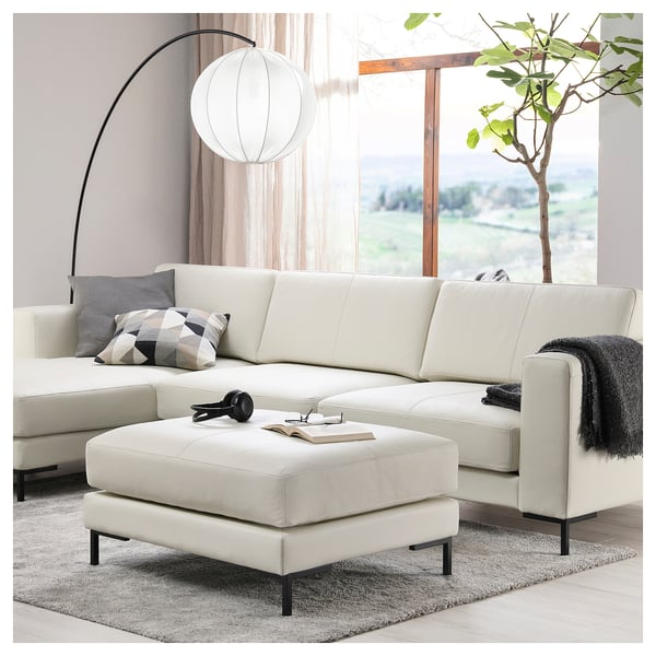 Salon moderne avec sectionnels FULLERÖ blancs, repose-pieds et pouf. Doté de lignes épurées et de coussins moelleux.
