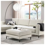 Salon moderne avec sectionnels FULLERÖ blancs, repose-pieds et pouf. Doté de lignes épurées et de coussins moelleux.