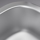 Évier en acier inoxydable, lisse, réfléchissant la lumière, mettant en valeur des matériaux de haute qualité.