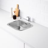 Évier de cuisine en acier inoxydable avec robinet sur comptoir blanc.