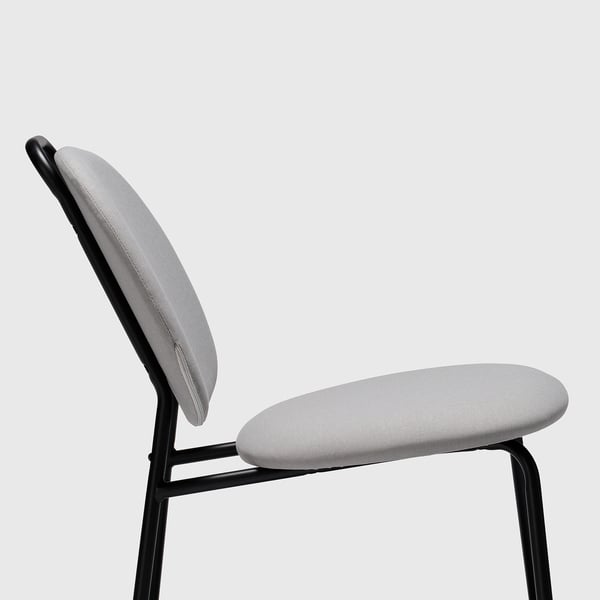 Chaise moderne avec assise et dossier en tissu gris clair, pieds en métal noir, angle confortable.