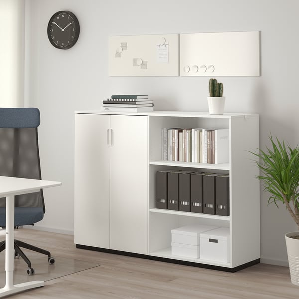 Unité de rangement de bureau GALANT blanche avec étagères ouvertes/fermées pour ranger les classeurs, les livres et les boîtes, à côté d’une chaise et d’un bureau bleus dans un espace de travail moderne.