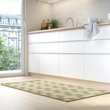 Cuisine moderne avec des armoires blanches, un parquet en bois clair et un tapis GÅNGSTIG vert.