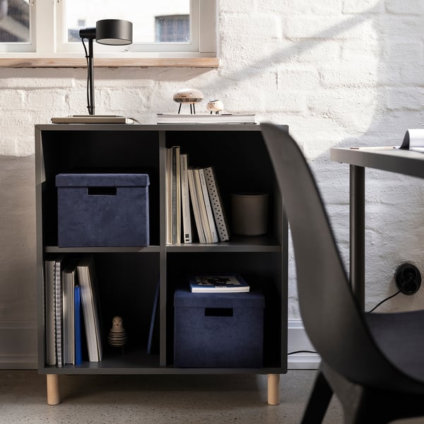 Bureau à domicile confortable avec boîte GJÄTTA en velours bleu sur étagère, éclairée par une lampe de bureau.