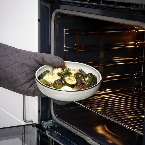 Personne plaçant le plat cuit dans le four. Produit : Plat à four GLADELIG.