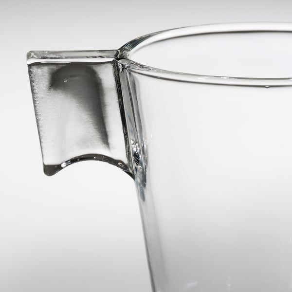 Pichet en verre transparent avec une poignée robuste, mettant en valeur la qualité et la clarté