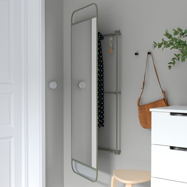 Miroir avec crochets de rangement derrière. S’accroche au mur avec des vis. Organise les accessoires près de l’entrée.