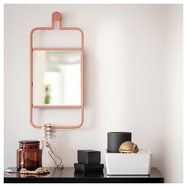 Un miroir mural nommé GRANVÅG en orange, de forme rectangulaire avec une étagère pour les accessoires.