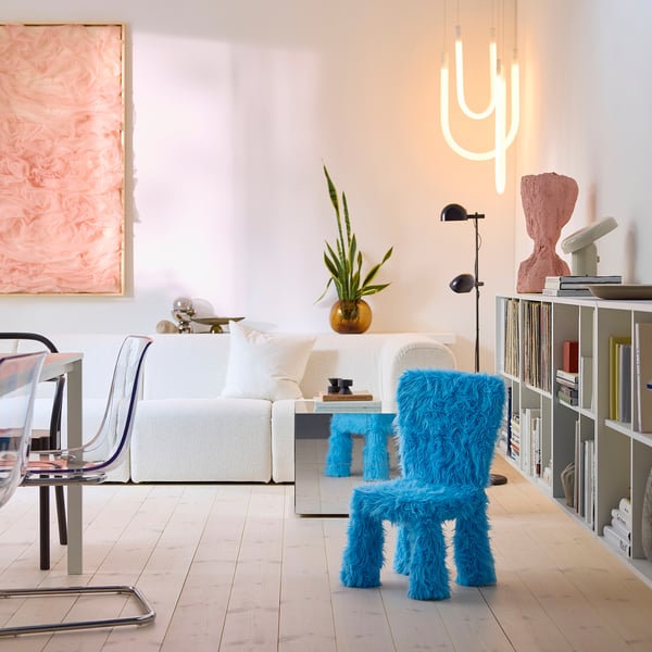 Salon moderne avec chaise d’enfant turquoise, polyester recyclé, décor minimaliste, art et néons.