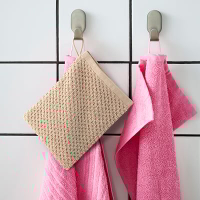 GULVIAL : des moufles coton beige et rose pendent larges sur des crochets.